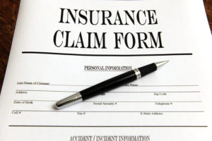 Blank insurance claim form with a pen.