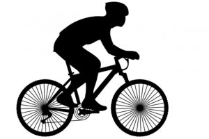 Black silhouette of cyclist wearing helmet to prevent bicycle accident injuries.