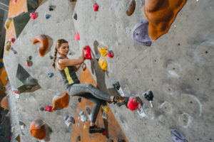 Woman on rock climbing wall has signed a not responsible for accidents waiver.