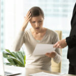 Boss Giving Dismissal Notification To Confused Female Office Wor