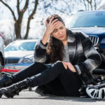 Full length of a young woman sitting on the asphalt with severe