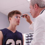 doctor checking young man's eye