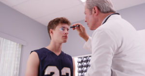 doctor checking young man's eye