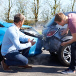 men looking at car crash