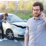 two men examining cars after wreck